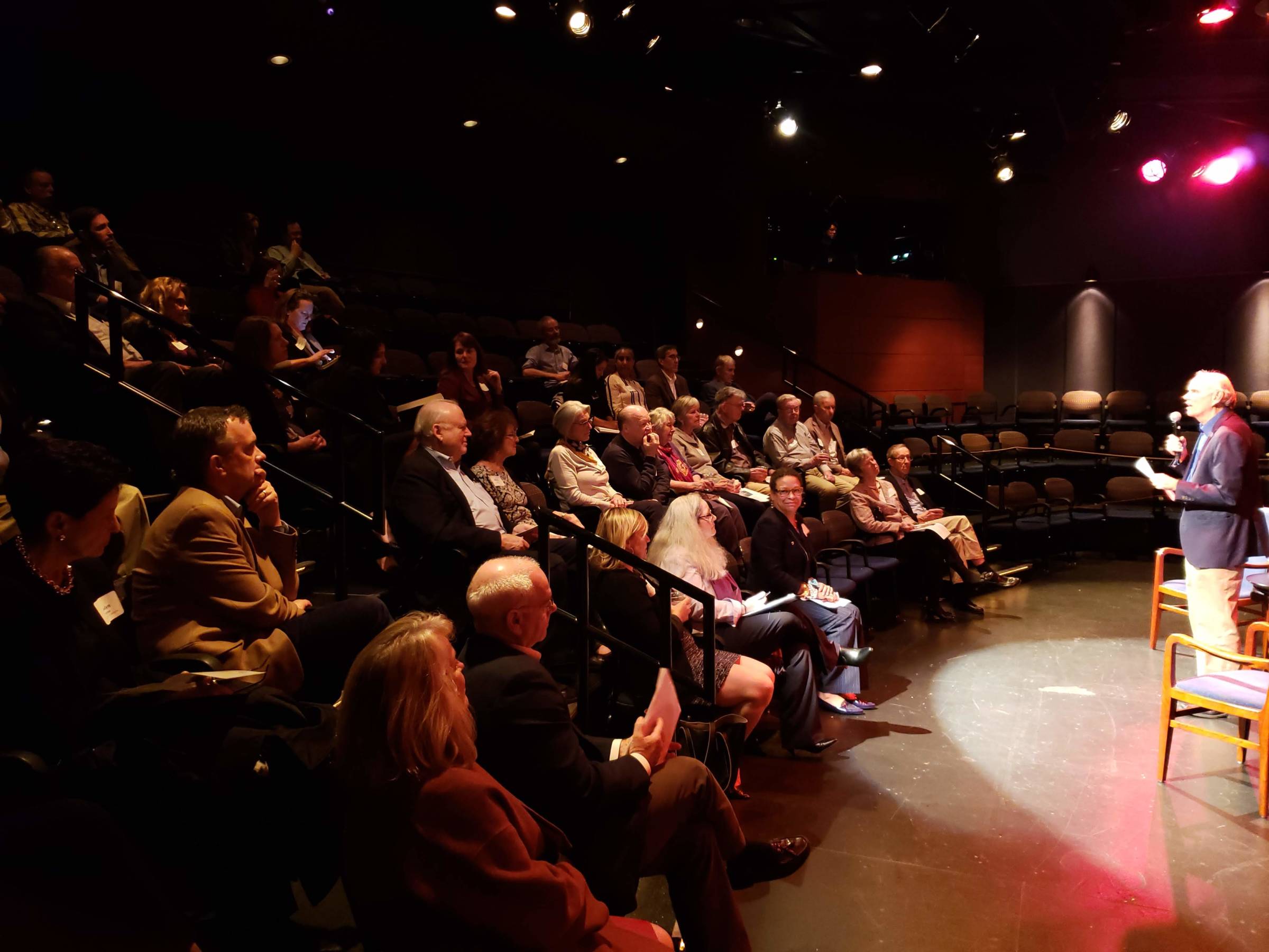 People listening to a speaker in a theater