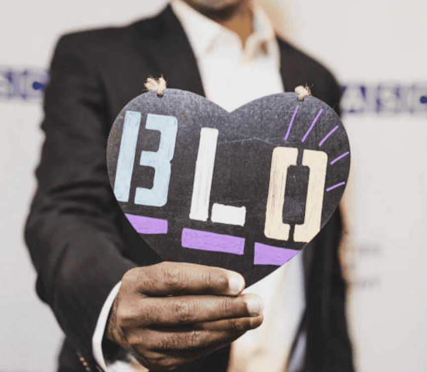 Man holding a hearts that says B.L.O.