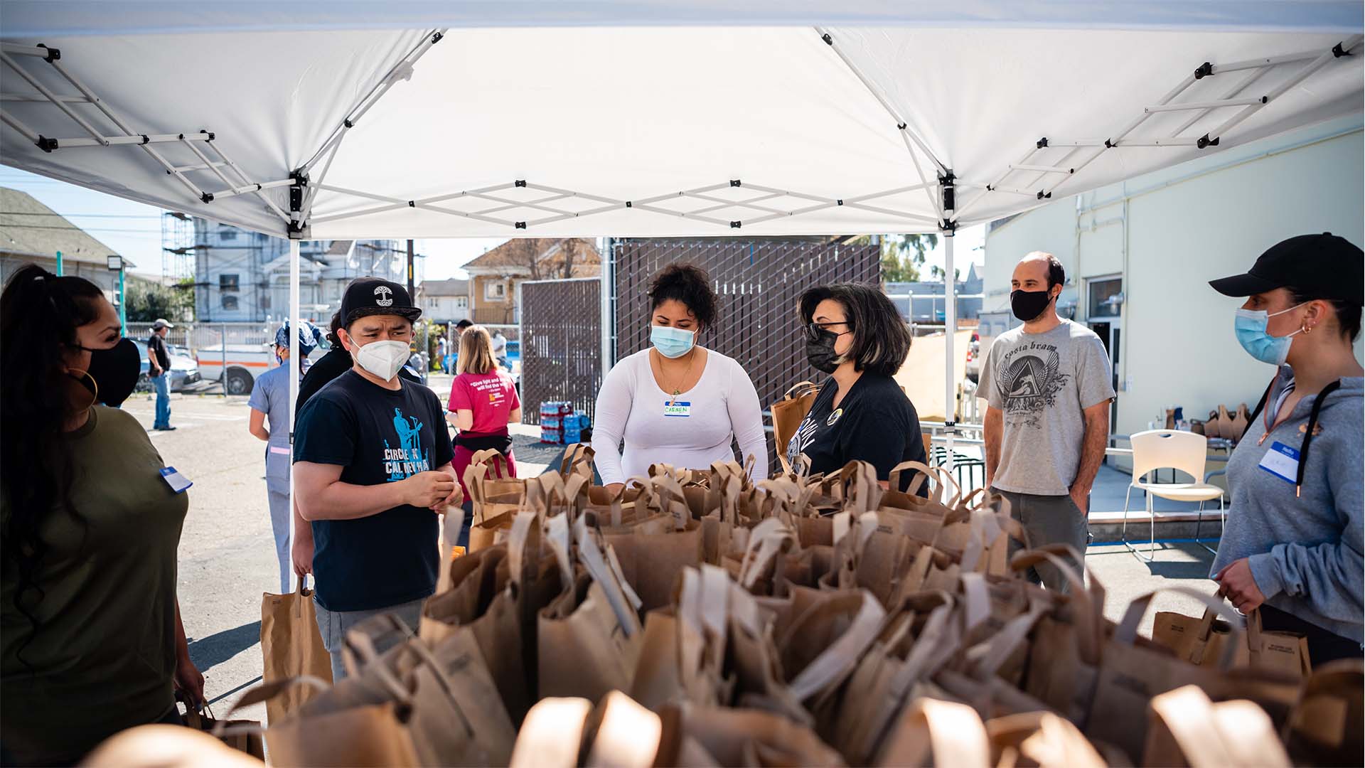 Group of people wearing masks, organizing paper bags