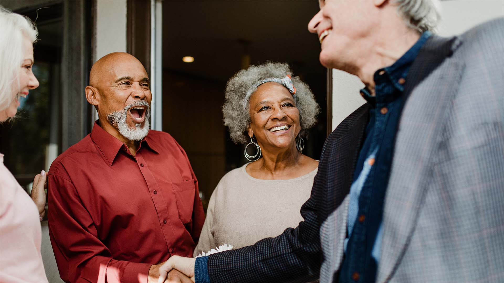 People at a party with two men shaking hands