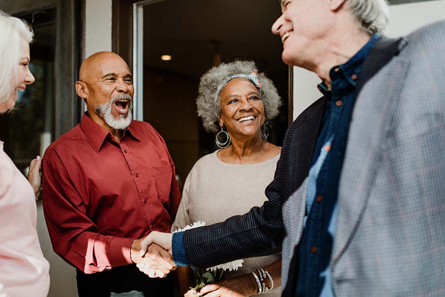 People at a party with two men shaking hands