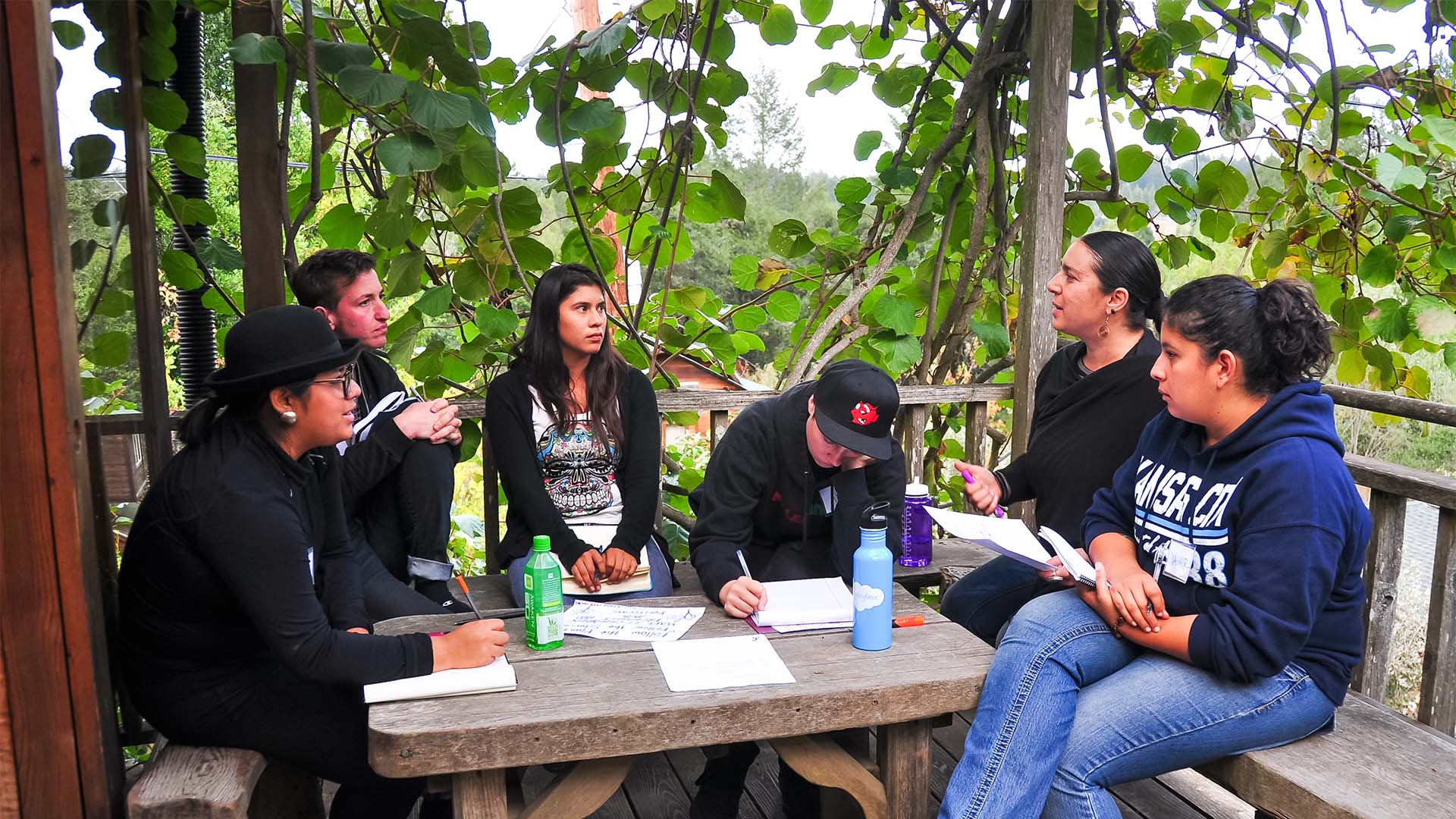 A small group of people discussing and writing notes