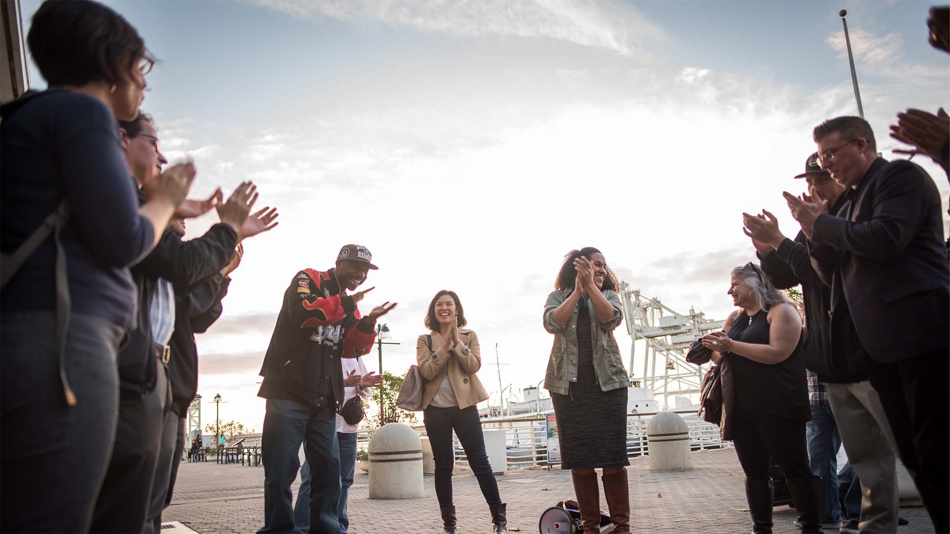 People standing in a circle, clapping their hands