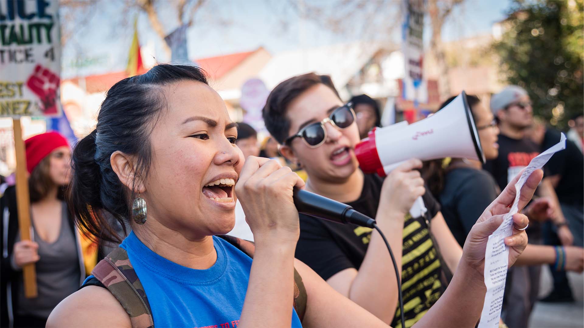 Woman speaking into a microphone at a protest