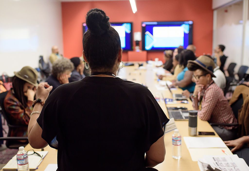 Woman speaking to a group of people in a meeting room