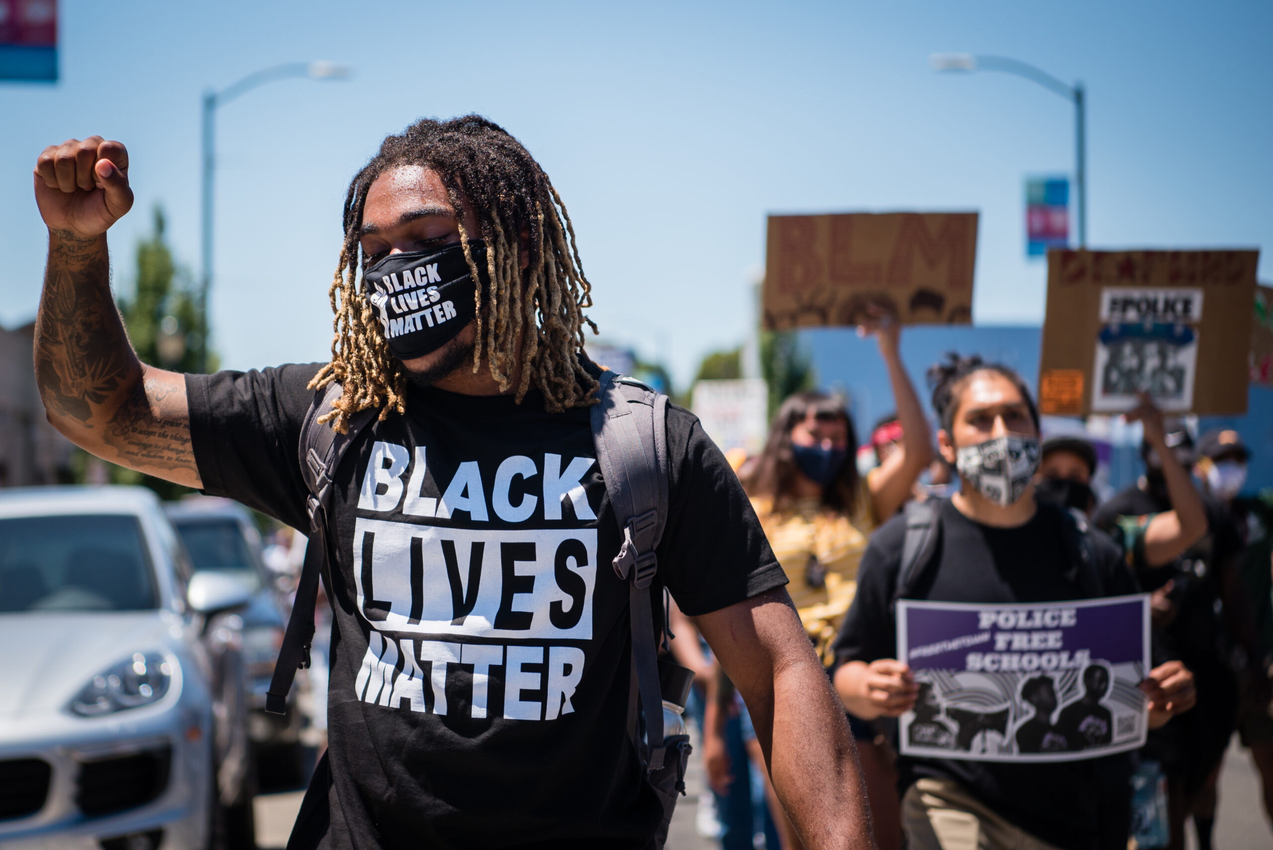 People at a protest with man in foreground raising a fist