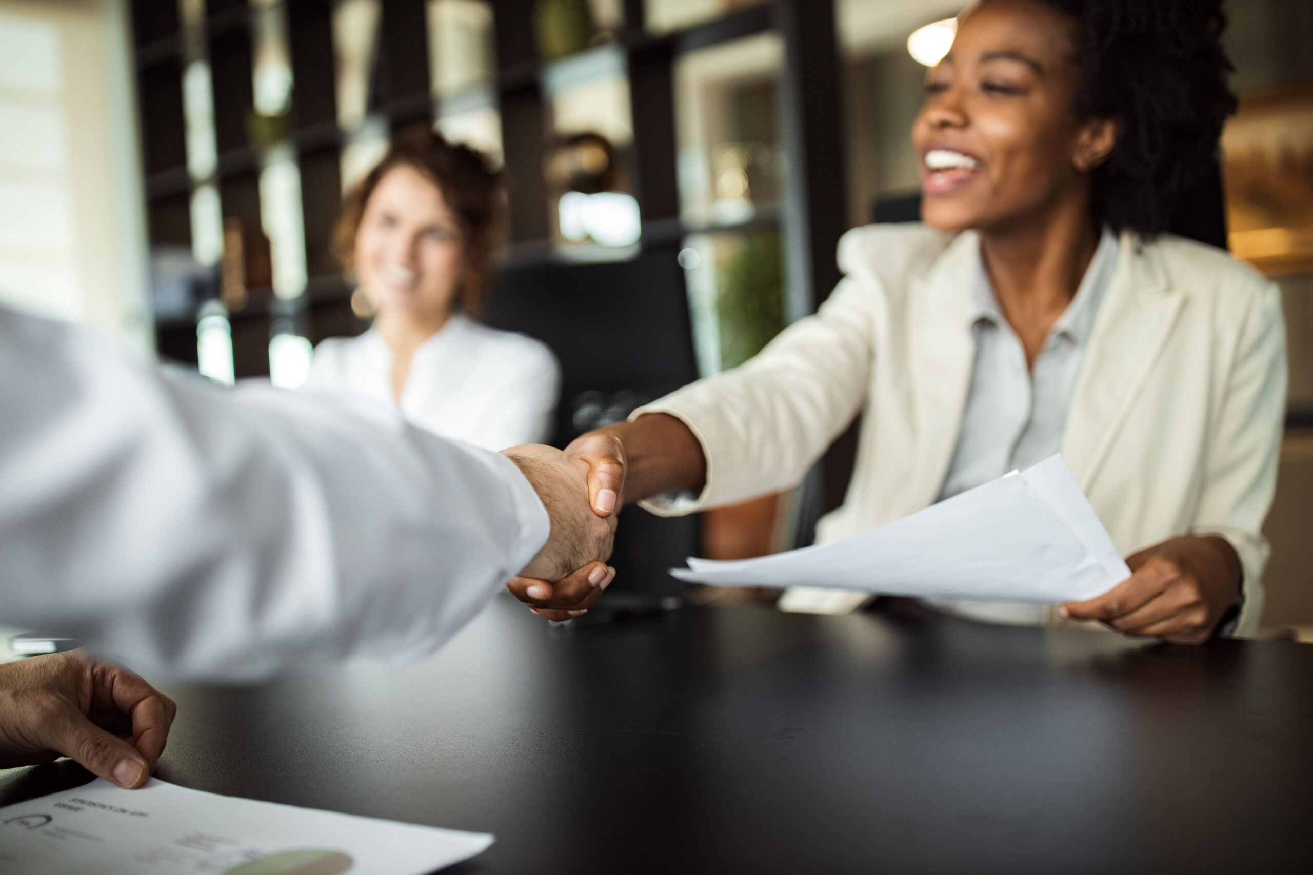 Woman in a meeting, shaking a man's hand