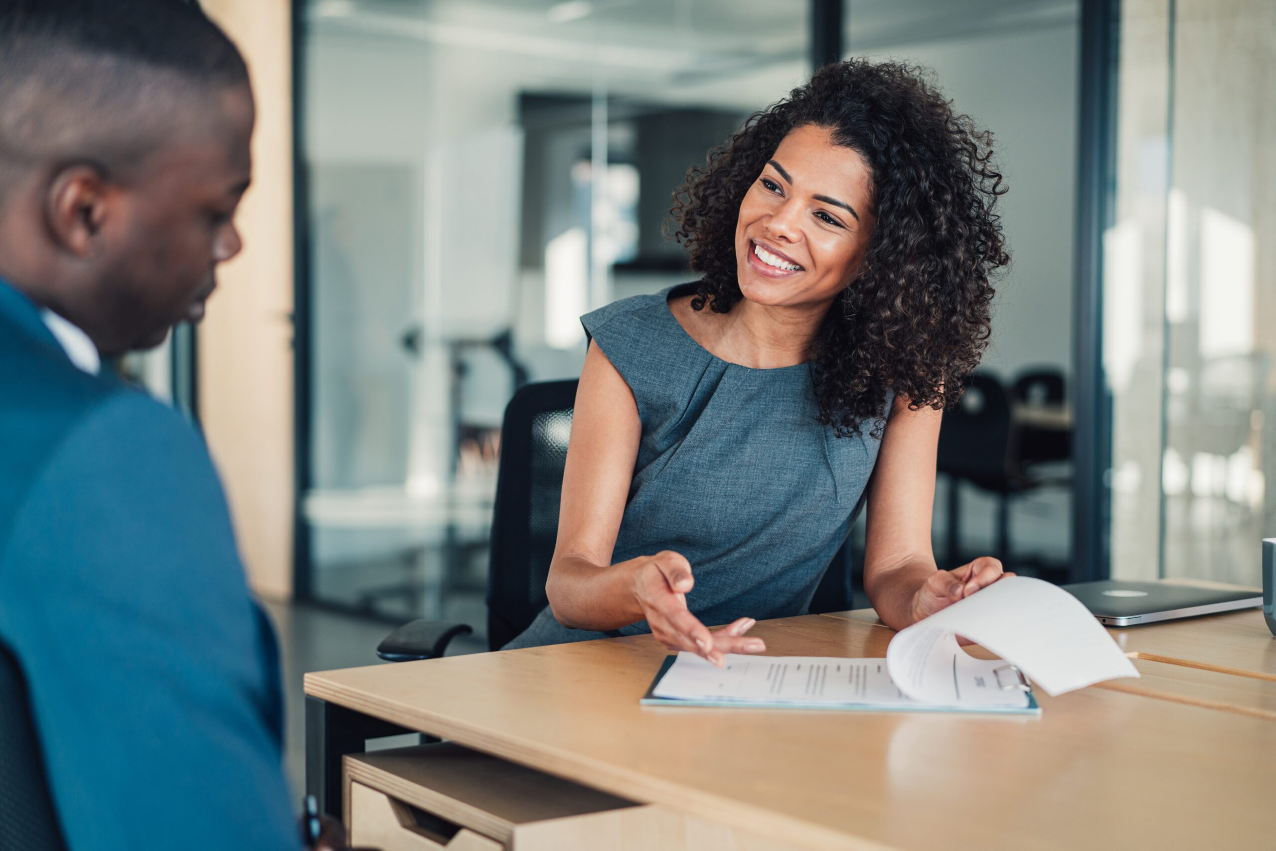 Woman presenting a document to a man in a meeting room