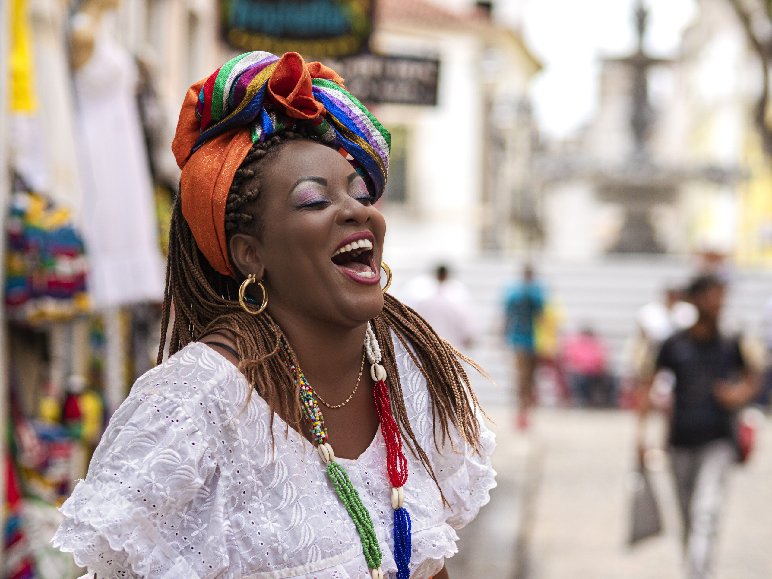 Happy Brazilian woman of African descent dressed in traditional Baiana costumes in the Historic Center of Salvador da Bahia, Brazil.